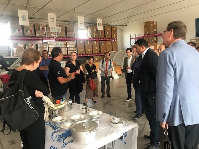 Listening to the utilization of first emergency relief goods inside the UNHRD warehouse. Photo: WFP/Harriet Spanos
